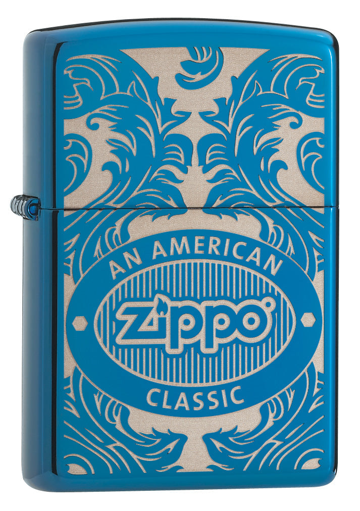 Blue Zippo lighter, front view, three-quarter angle, surrounded by a laser-engraved filigree motif showing the Zippo logo and "an american classic".