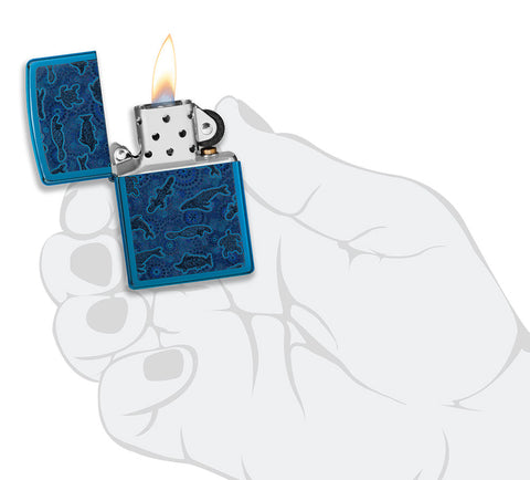 Zippo Lighter Front View Opened and Lit in High Gloss Blue with Illustration of Aboriginal Art Style Sea Creature in Stylish Hand