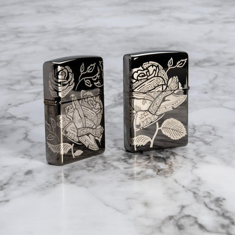 Lifestyle image of Currency Design Black Ice Windproof Lighter showing the front and back on a marble surface