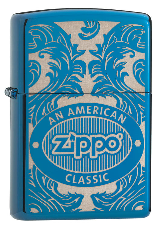 Blue Zippo lighter, front view, three-quarter angle, surrounded by a laser-engraved filigree motif showing the Zippo logo and "an american classic".